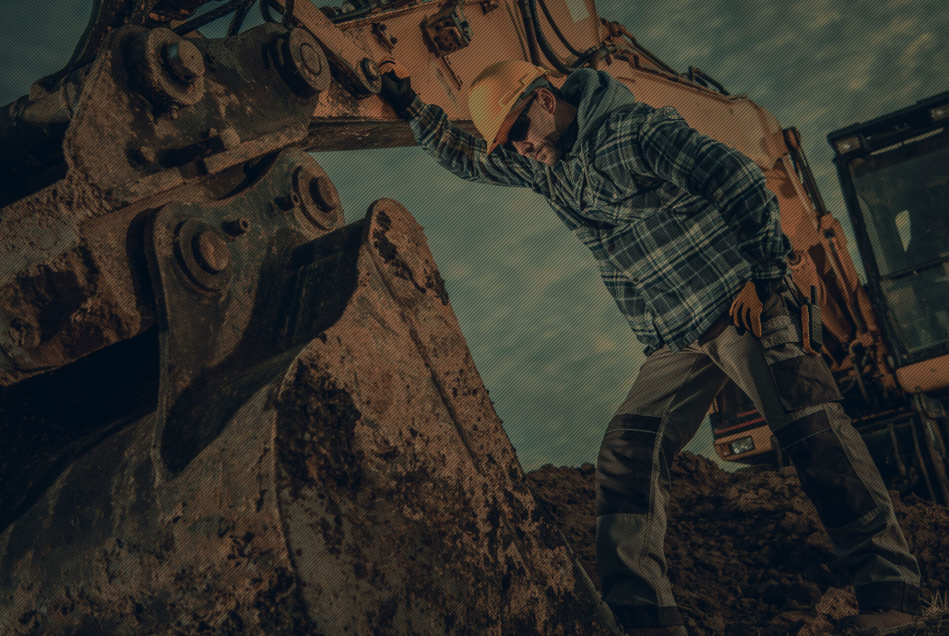 Worker in fron of a backhoe